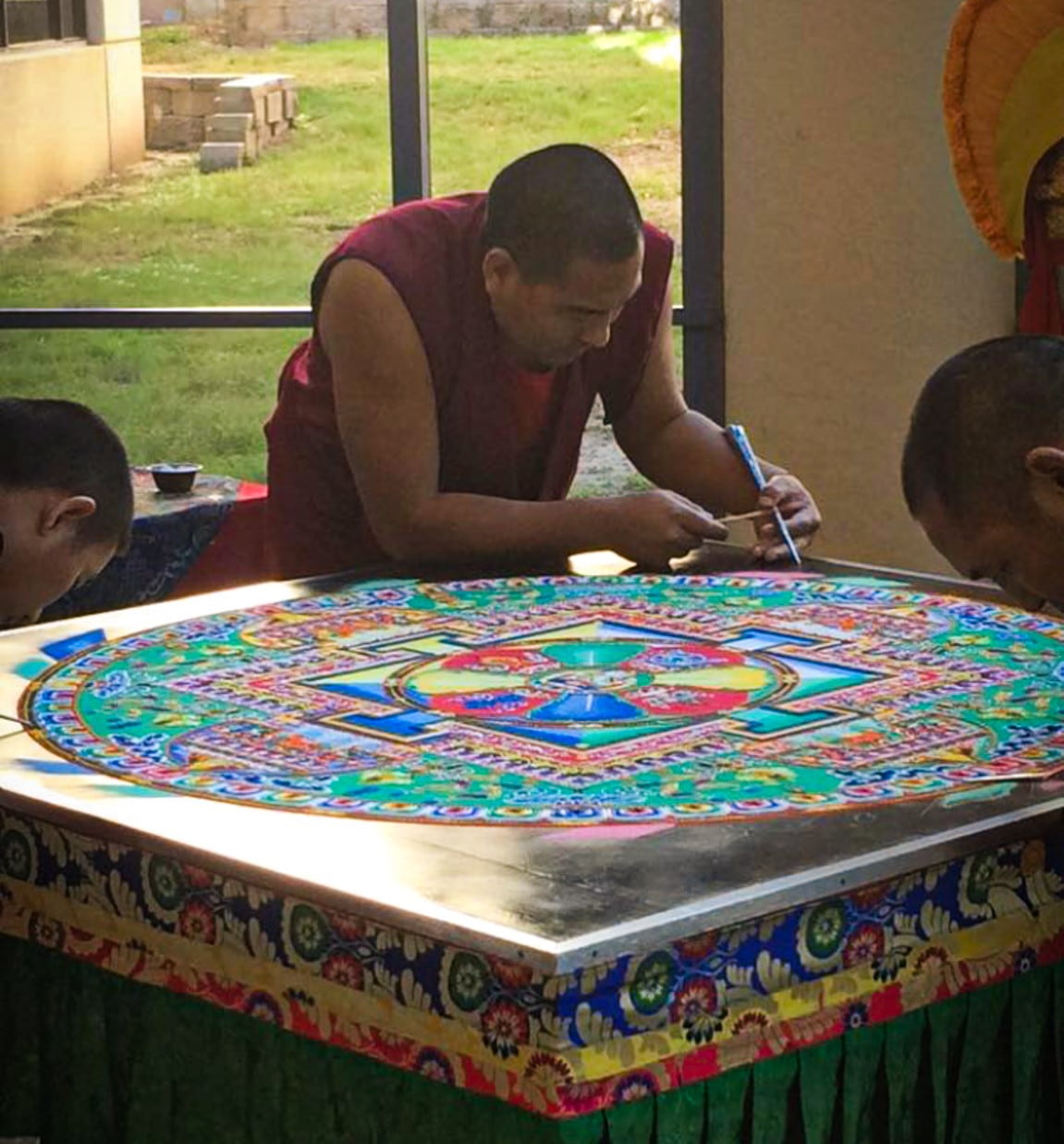 three monks creating a mandala